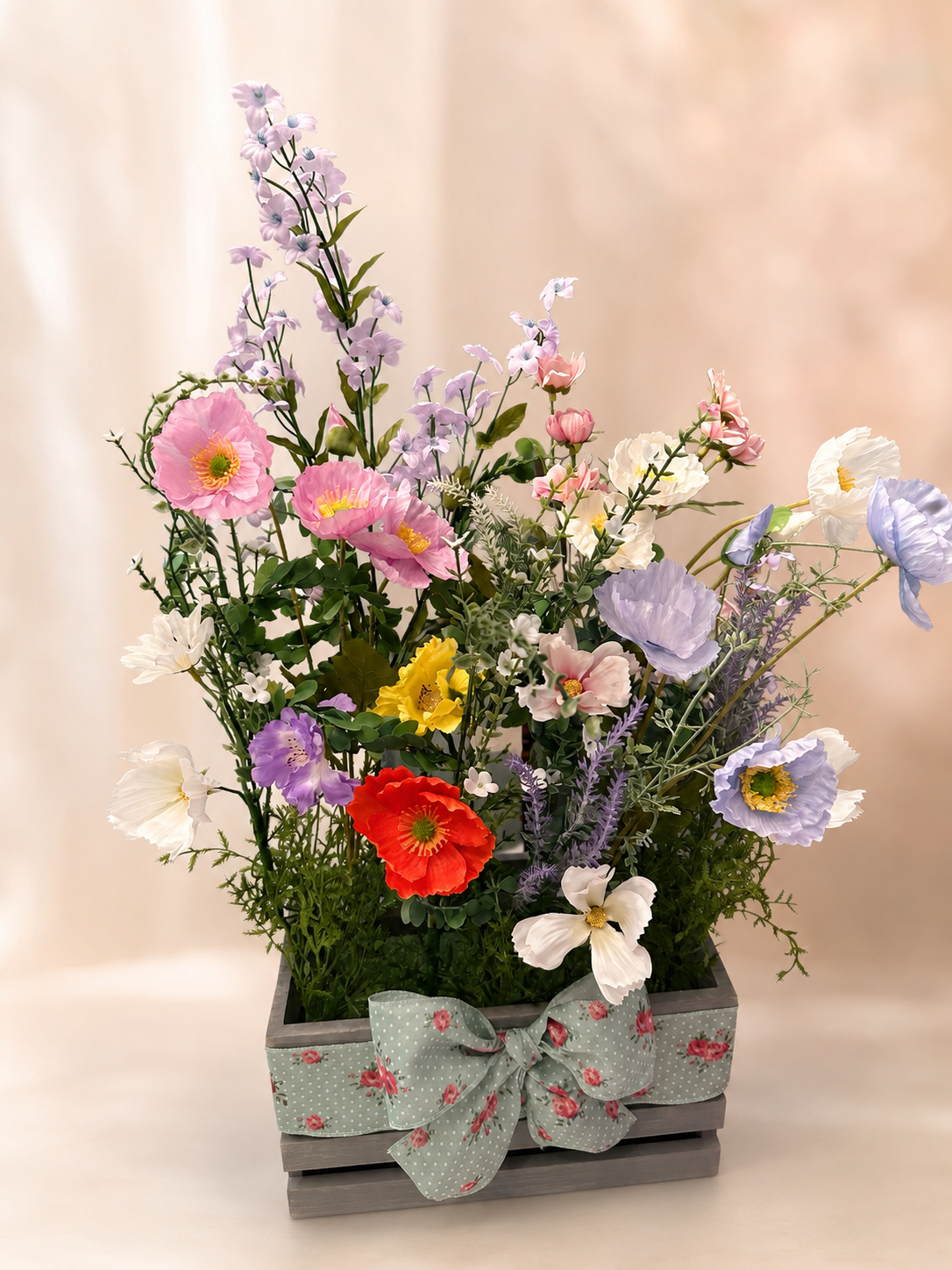 Colorful handcrafted baby-shower flower arrangement in a ribboned wooden box