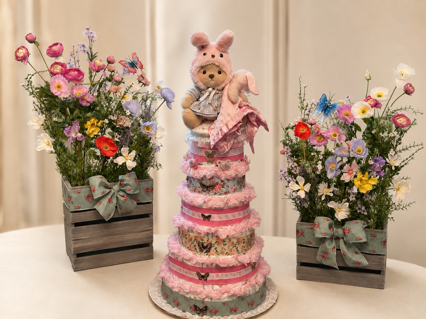 Pink custom diaper cake with coordinating baby-shower flower arrangements